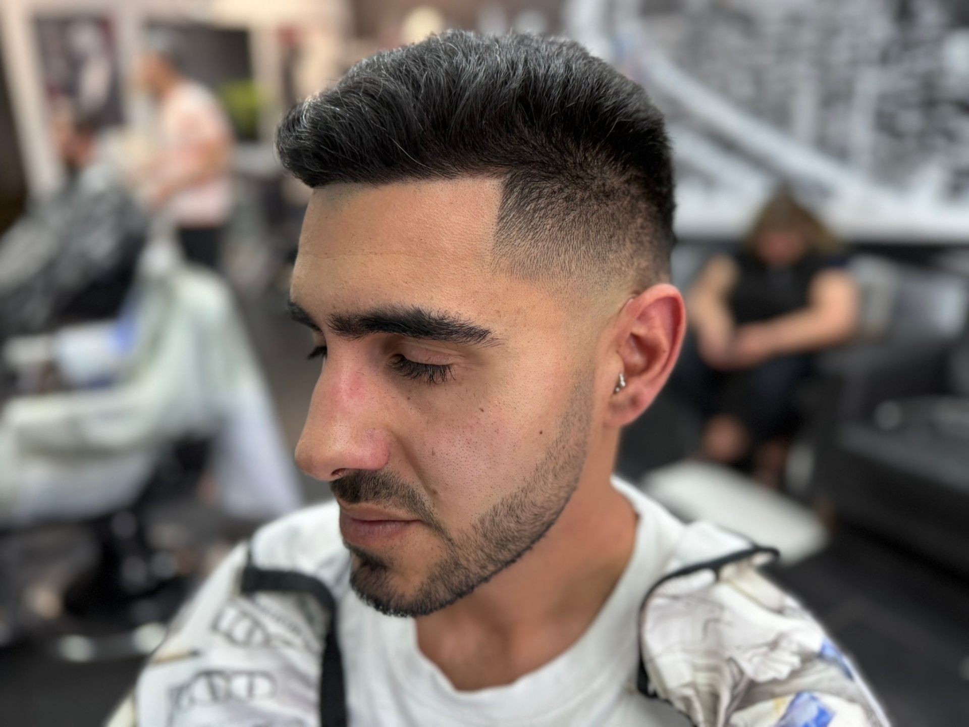 Clean taper fade with a textured curly top at a Denver barbershop
