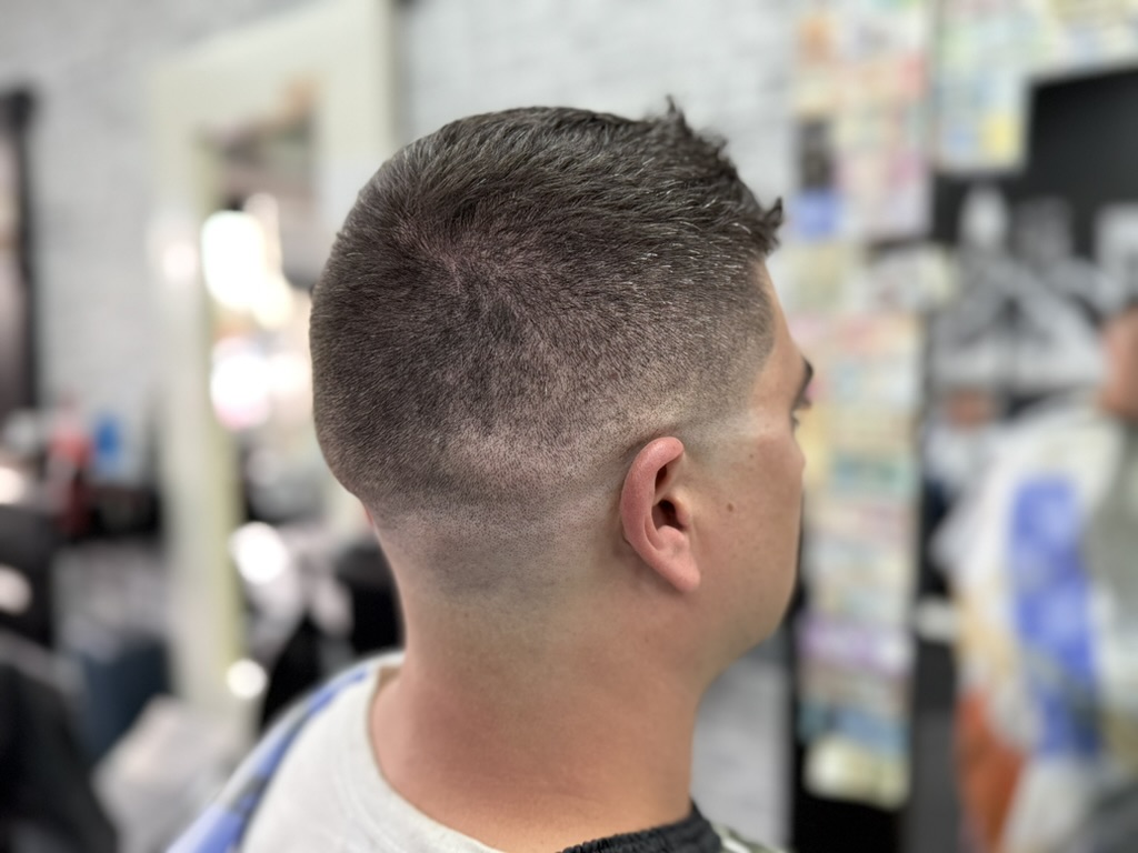 Modern fade haircut with an etched hair design at a Denver barbershop