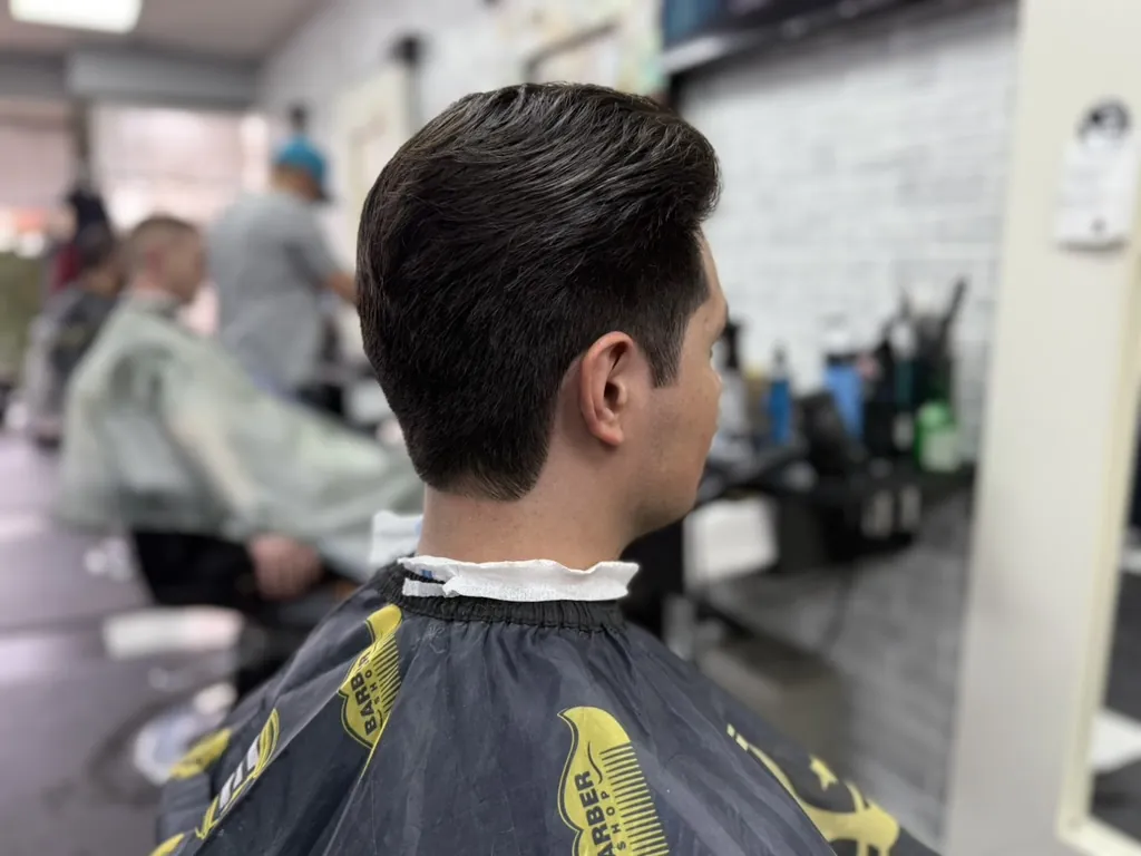 Side profile of an afro taper haircut with natural curls at a Denver family barbershop