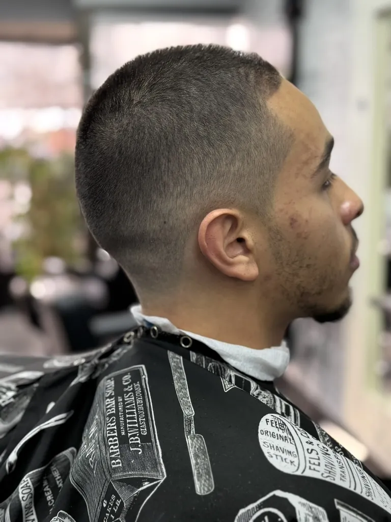 Side profile of a man with a bald skin fade haircut and sharp line-up at Wise Guys Barbershop in Denver